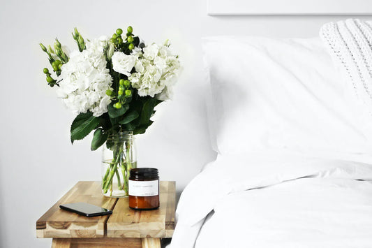 Calming white bedroom scene with fresh flowers and spa-inspired atmosphere.